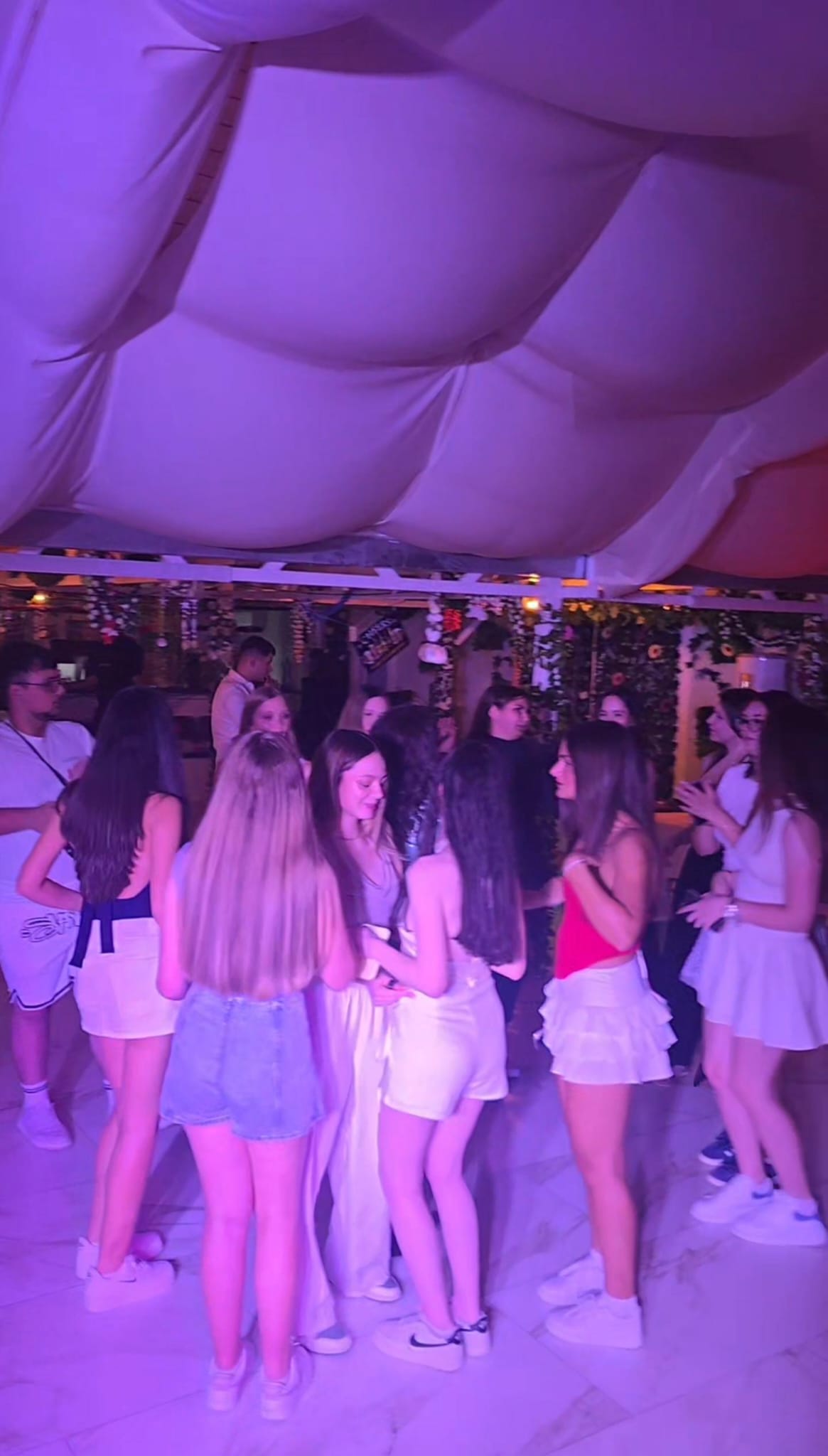 Invitați dansând la petrecere sub lumini mov